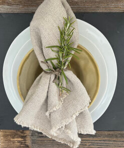 Kaya fringe napkin with hemp cord rosemary sprig and dishes